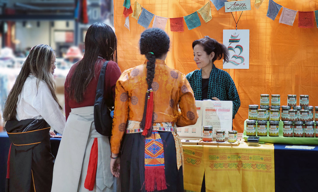 Jolma serving customers at a farmers market, sharing Tibetan-inspired foods made with care and conversation.